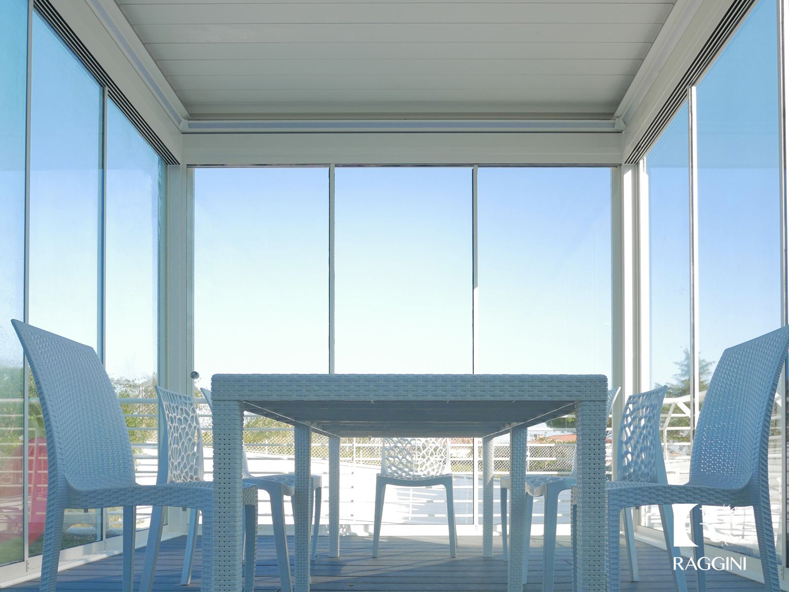 Pergola bioclimatica bianca con vetrate scorrevoli su una terrazza